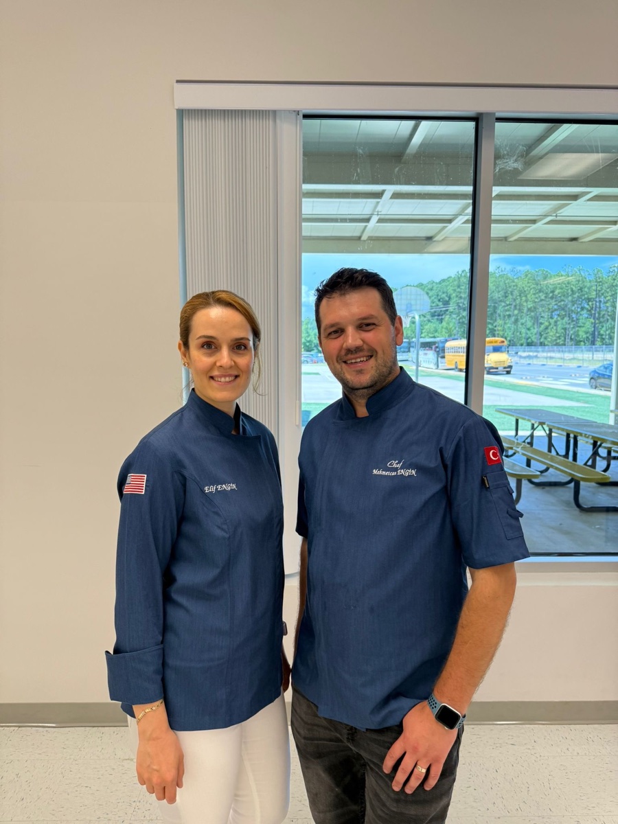 Chef Can Engin and Chef Elif Engin, in matching navy chef coats.